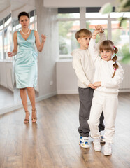 Passionate tween dancers, girl and boy practicing ballroom dancing in dance studio, gracefully...
