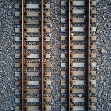 Top view two parallel railway tracks. Old wooden sleepers with new concrete sleepers. Industrial background. Gravel base. Transportation infrastructure. Perspective shot. Travel concept.