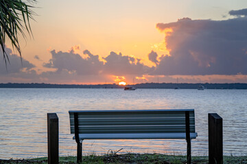 Obraz premium Tin Can Bay, sunrise dawn, park bench overlooking the water, travel tourism tourist destination, relax weekend family holiday vacation, Queensland Australia