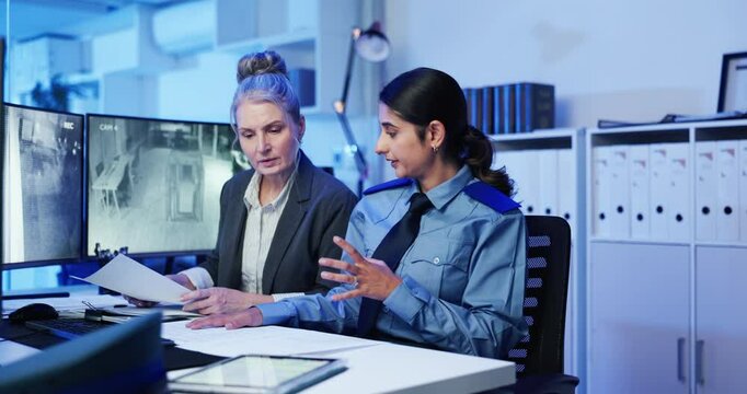 Women, security and documents in surveillance office for review, planning or strategy by monitor. People, paperwork and teamwork with feedback in discussion, advice and notes for safety services