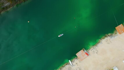 Aerial top down view of woman lying on a paddleboard on the lake in Cap Cana