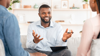 Family Psychotherapy. Friendly Black Therapist Consulting African American Couple At His Office,...