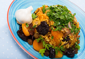Pilaf with mutton, prunes, dried apricots, raisins, oriental spices, garlic and greens