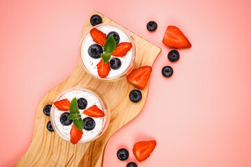 Healthy Chia Pudding in a Glass with Fresh Berries on Pink Background. Chia Pudding with Blueberries and Strawberries. 
Super food. Detox, diet, body cleansing