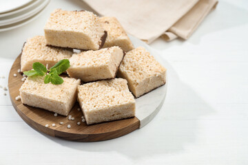 Delicious puffed rice bars and mint on white wooden table, closeup. Space for text