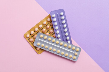 Blisters of contraceptive pills on color background, top view