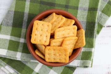 Tasty salty crackers on white wooden table, top view