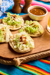 Traditional mexican food sopes, made with corn, beans, salsa and cheese