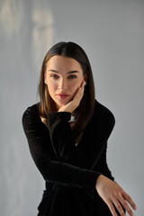 Fototapeta premium Portrait of a beautiful young brunette woman in a black dress