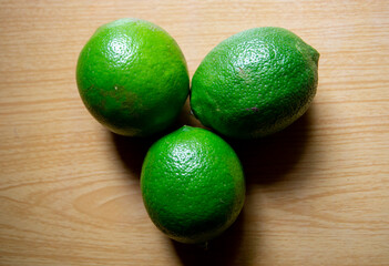 Closeup green lemons on wooden table background
