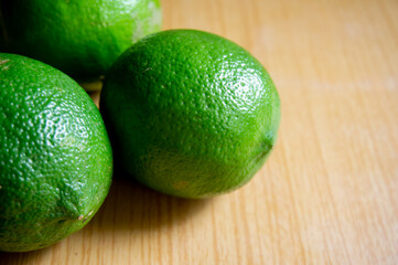 Closeup green lemons on wooden table background