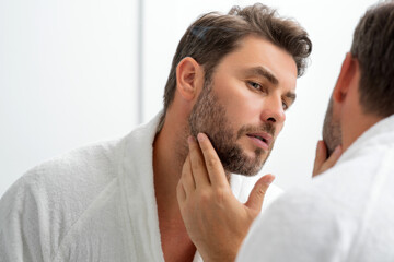 Sexy sensual man with perfect skin touch face after shaving. Skin care healthcare cosmetic...