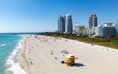 Beach in Miami with sunbed on a sandy beach with ocean waves. Miami Beach paradise with stunning views. South Beach Miami lifeguard post. Peaceful seaside retreat in Miami. Coastal relaxation.