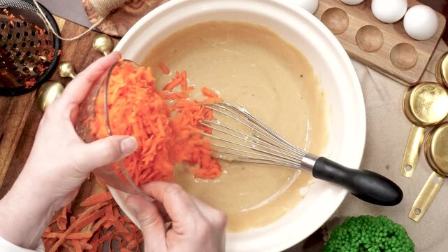 Baking a triple layer carrot cake with cream cheese icing.  A perfect spring time cake made with fresh carrots. Cake decorating with cream cheese frosting.  Homemade cake for a family gathering.