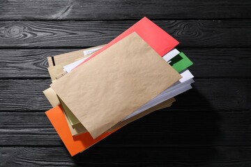 Different paper envelopes and parcel on black wooden table. Post office