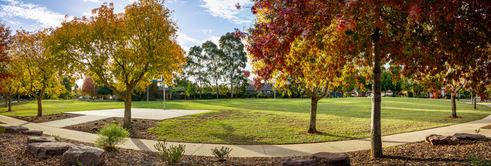 Panoramic view of a suburban park in Werribee, Melbourne, Australia with autumn foliage, a public...