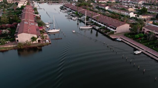 A drone over a small town on a lake. Marinas, Cloudy summer sunset. Sibari, Italy.