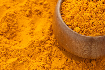 Finely dried turmeric powder in a wooden bowl - Curcuma longa