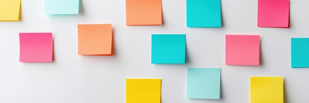 Sticky notes and paper tabs arranged in an organized manner on a clean white desk for effective planning and organization tasks in an office setting