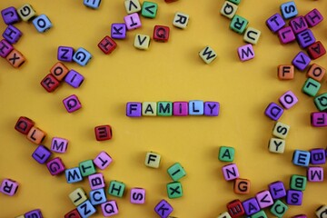 Colorful Letter Blocks on Yellow Background Highlighting the Word 'FAMILY'