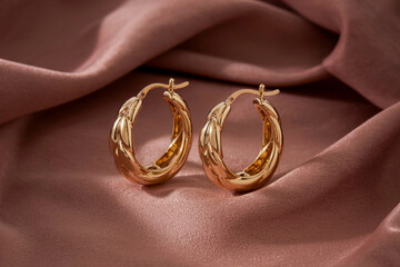 Elegant Golden Hoop Earrings On A Luxurious Dusty Rose Satin Fabric © MASURA 