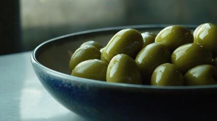 A close-up of green olives in a bowl, showcasing their glossy surface and rich color.