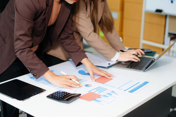 The business team analyzes revenue charts and graphs with laptop and tablet.Business analysis