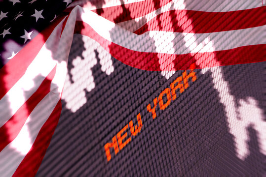 Flag of the United States of America and price board at the New York Stock Exchange