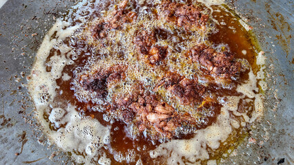 Fried chicken cooking in hot oil at a local street vendor