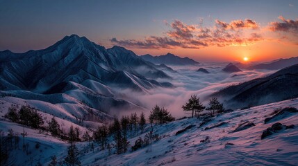 Obraz premium Majestic snow-capped mountain range at sunrise, shrouded in mist.