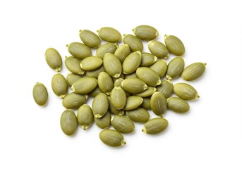 A heap of green pumpkin seeds scattered on a white surface in a close up studio shot view