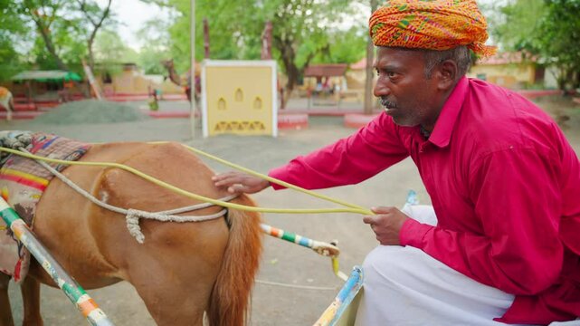 Turbaned rider gently strokes steed from behind