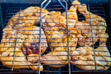 Chicken being grilled in a grid close-up