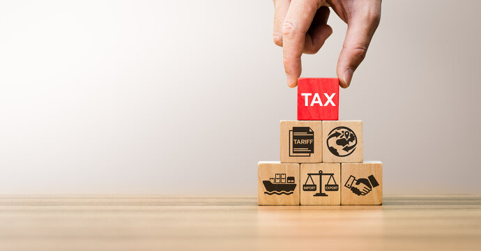 Global Trade Tariff Concept with Hand Stacking Wooden Blocks Showing Tax, Tariff, Import, Export, and International Business Icons Representing Economic Policy and Cross Border Commerce