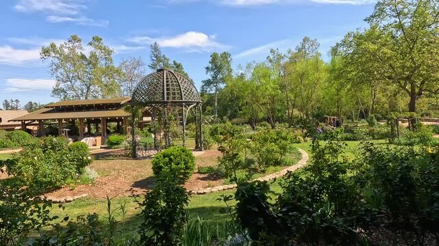 footage of a gorgeous spring landscape with a gazebo, colorful flowers and lush green trees and plants at Descanso Gardens La Canada Flintridge California USA