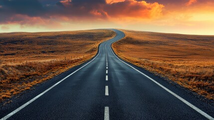 Fototapeta premium Scenic Road Curving Through Golden Landscape at Sunset