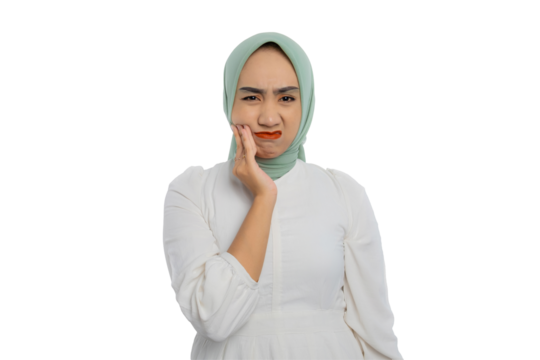 Unhealthy young Asian woman in green hijab and white blouse suffering from toothache, touching her cheek and grimacing, feeling pain in her tooth isolated on transparent background