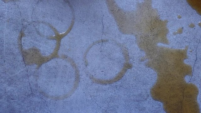 Coffee stains create unique patterns on a concrete surface