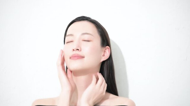 若い女性の艶と素肌感が美しい手を添えるビューティーイメージの目を閉じるクローズアップの動画