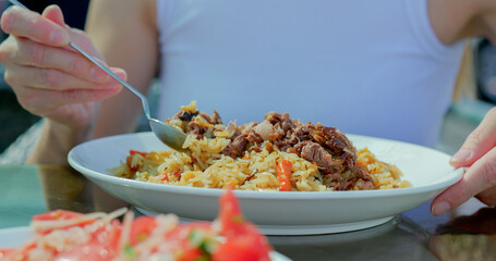 Eating Traditional Uzbek Pilaf with Fresh Salad