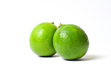 Side view of two (2) lime fruit isolated on white background. Close up. Clipping path.