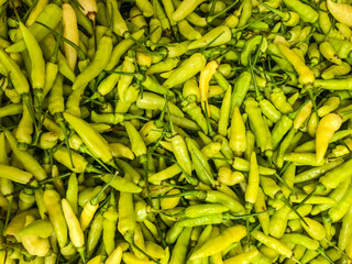 Green hot chilli peppers pattern texture background. Close up. Landscape. Backdrop. Street vegetable market. Group. Top view, high angle, above. Agriculture. Harvest.
