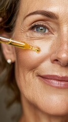 Obraz premium Mature woman carefully dropping anti aging serum onto facial skin, demonstrating skincare routine with precision and self care in later years