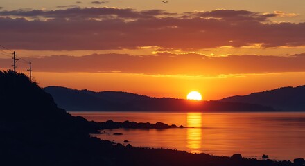 Coastal Sunset: Fiery Sky over Silhouetted Shore