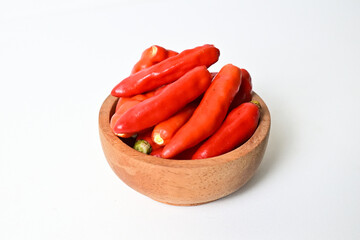 Photo of Fresh Red Chili Peppers on the little wooden bowl. Isolated on White Background. Close up view. Clipping path.