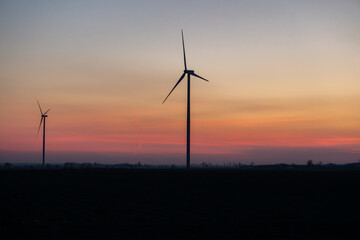 Windmills against the colorful sky at sunset