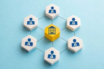 The concept of business structure and teamwork is conveyed through a central yellow building block connected to six white blocks representing individuals, forming an interconnected network on a light 
