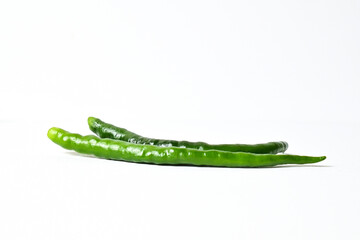 Close up view of two (2) fresh green chili peppers isolated on white background. Clipping path. Side view.