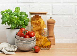 Cherry tomatoes, basil, pasta and olive oil creating an italian culinary scene