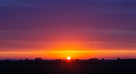 Fototapeta premium Sunset Landscape: Fiery Horizon, Silhouetted Trees, Serene Evening